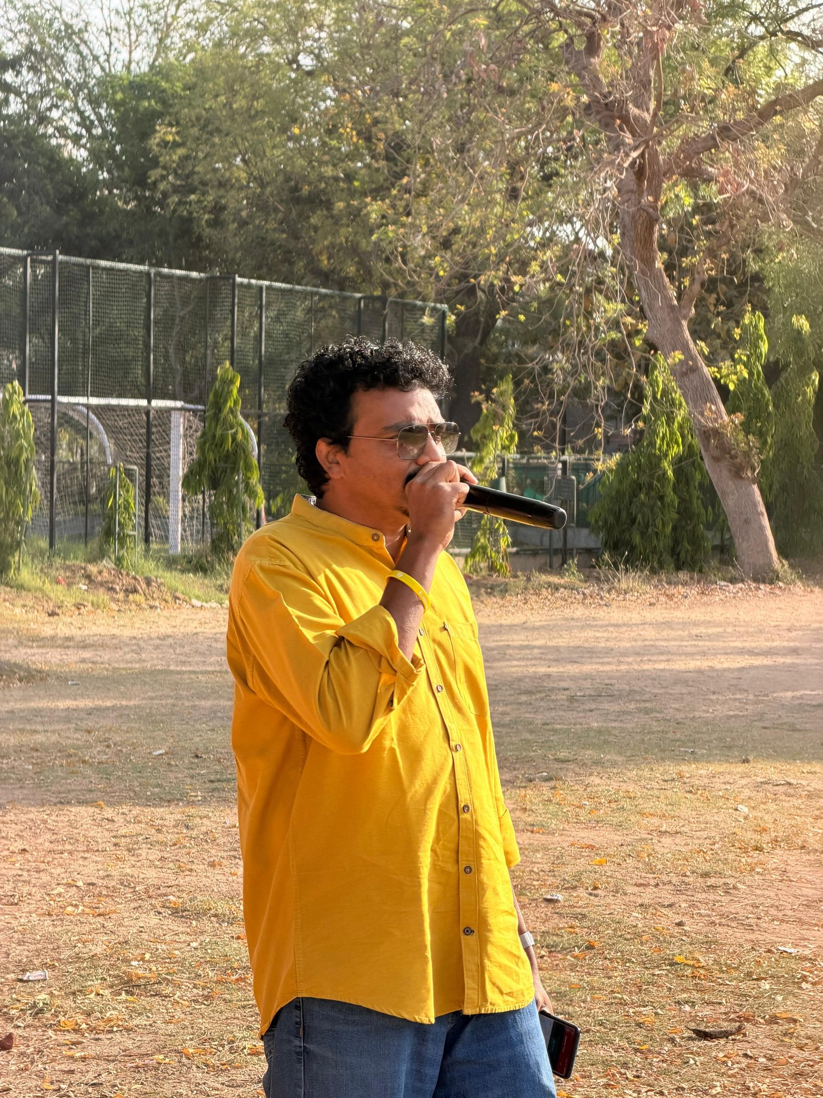 Joseph John on the mic at a cricket ground